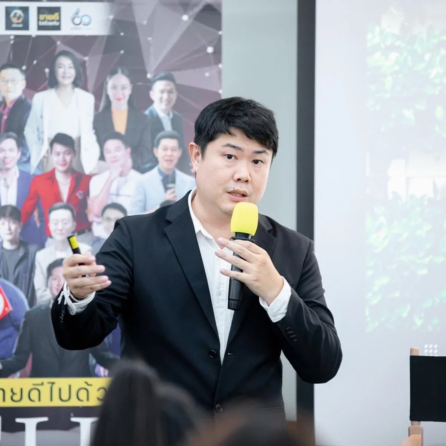 ซินแสแบงค์บนเวทีสัมมนา ถือไมโครโฟน แบ่งปันความรู้ศาสตร์จีนกับผู้ฟัง — โทนอบอุ่น มืออาชีพ